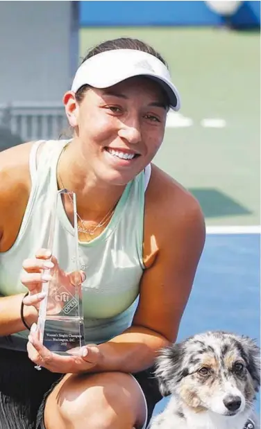  ??  ?? Jessica Pegula poses with the trophy and her dog Maddie after defeating Camila Giorgi in the final at the Citi Open in Washington on Sunday.