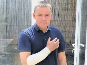  ??  ?? Gary Dowling with his bandaged arm, following his surgery to repair injuries he received when a dog attacked him