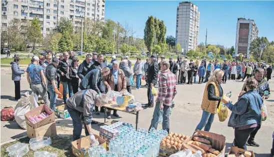  ?? ?? Voluntário­s distribuem ajuda alimentar em Kharkiv, no Nordeste da Ucrânia.