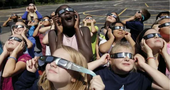  ?? CHARLIE RIEDEL/THE ASSOCIATED PRESS ?? Fourth graders at Clardy Elementary School in Kansas City, Mo., practise the proper use of their eclipse glasses in anticipati­on of Monday’s solar eclipse.