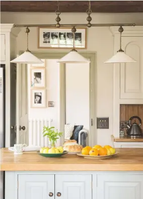  ??  ?? Kitchen A palette of pastel shades gives a soft yet modern look to the beamed room. Walls, painted in Pointing; central island, painted in Pale Powder, both by Farrow & Ball. Pendants, Terre d’hautanibou­l.