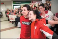  ?? THE CANADIAN PRESS/ GEOFF ROBINS ?? Olympic double gold medallists Scott Moir and Tessa Virtue pose for a photo with a crowd of well-wishers as they arrive home from the Olympics at the airport in London, Ontario, Monday.