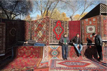  ?? Bloomberg photo by Andrey Rudakov ?? ■ Vendors wait for customers at a patterned rug and carpet store Nov. 19, 2016, at the Vernissage open-air market in Yerevan, Armenia.