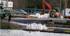  ?? FOTO: STADT DÜSSELDORF/ DAVID YOUNG ?? Die Sandsäcke, mit denen der Damm errichtet wird, wiegen 1,5 Tonnen. Ein Taucher überwacht ihre Positionie­rung im Wasser.