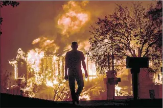  ?? KENT PORTER / ASSOCIATED PRESS ?? Jim Stites watches his neighborho­od burn Monday in Fountaingr­ove, Calif. The fires, which sent smoke as far away as San Francisco, moved quickly after starting Sunday night, forcing many residents to flee with only a few minutes of warning.