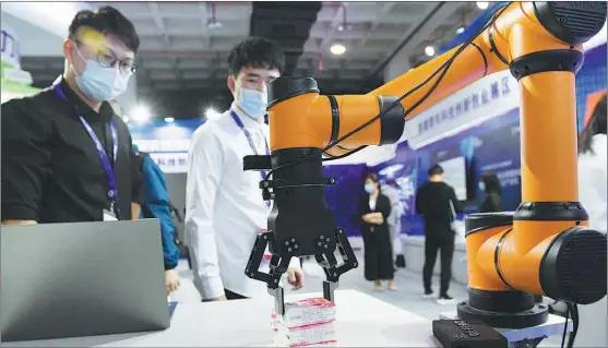  ?? JU HUANZONG / XINHUA ?? Visitors check out a smart robot during a high-tech exhibition in Beijing on Sept 17.