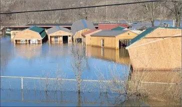  ?? Photog r aphs by Kate Munsch AFP/ Getty I mages ?? THE MERAMEC RIVER f ills homes in Arnold, Mo. Flooding has been blamed for 24 deaths in Missouri and Illinois, and more rivers were expected to crest in southeast Missouri and Tennessee.