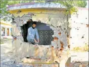  ??  ?? A resident inspecting a bathroom of a school damaged by mortar shells fired from the Pakistan side at Jhanghar in Nowshera.
