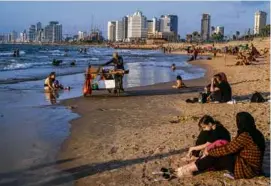  ?? MOISES SAMAN/NEW YORK TIMES ?? Beachgoers sat along the shore in Tel Aviv in August. Arab citizens of Israel, many of whom want to be identified as Palestinia­ns, make up some 18 percent of the population,