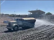  ?? JUSTIN COUCHOT — ENTERPRISE-RECORD ?? Silver Dollar Speedway track surface preparer Lowell Moural drives the water truck with his assistant Mark Cooper on turn four of the track on Friday at Gold Cup at Silver Dollar Speedway in Chico.