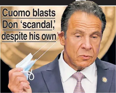  ??  ?? NOW EAR THIS: Gov. Cuomo fiddles with his mask Monday at a news conference, where he lashed into President Trump’s virus response and touted his own action in combating the disease.