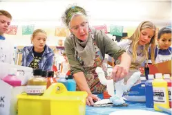  ?? GABRIELA CAMPOS/THE NEW MEXICAN ?? Wood Gormley Elementary art teacher Mary Olson shows sixth-graders how to paint papier-mâché figures during class Friday. Olson is this year’s recipient of the Arts Educator of the Year award from the New Mexico Art Education Associatio­n.