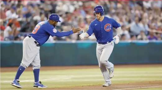  ?? CHRIS CODUTO/AP ?? Cubs third-base coach Willie Harris greets Yan Gomes as he circles the bases on his solo home run in the fourth inning Saturday night.