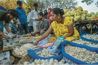  ?? ATUL LOKE/THE NEW YORK TIMES ?? A QR code perches atop a basket of garlic this week at a roadside produce vendor’s stall in Mumbai, India.