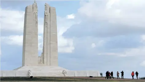  ?? PHILLIPPE HUGUEN/GETTY IMAGES ?? Visitors look at the Canadian National Vimy Memorial in Vimy, France. The monument is inscribed with the names of 11,285 Canadian soldiers who were killed in France during the First World War and whose final resting place was unknown.