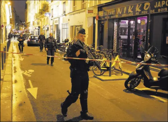  ?? Thibault Camus The Associated Press ?? A police officer cordons off the area after a knife attack Saturday in central Paris.