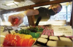  ?? ROBERT F. BUKATY — THE ASSOCIATED PRESS ?? Beth Duckworth fills a display cabinet with sweet treats at The Goldenrod, a popular restaurant and candy shop in York Beach, Maine. The business is looking to hire 30to 40more workers in addition to the 70 or so it now employs.