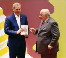  ?? JESSICA GÓMEZ ?? José Báez Guerrero mientras entrega su libro a Luis Abinader, presidente de la República.