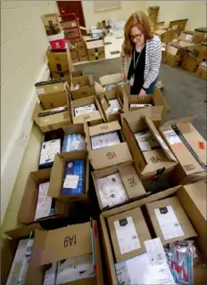  ?? Darrell Sapp/Post-Gazette ?? Sto-Rox Middle School counselor Katie Couch goes through some of the boxes containing donations Wednesday in the Sto-Rox School District. Ms. Couch started a social media campaign, and people have responded with donations of paper and other school supplies.