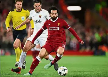  ?? — AFP ?? Genius at work: Liverpool’s Mohamed Salah (right) shielding the ball from AS Roma’s Kevin Strootman during the UEFA Champions League semifinal first leg at Anfield.