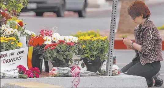  ?? Review-Journal file ?? An Albertsons employee lights a candle June 4, 1999, at a memorial at the store where Zane Floyd, then 23, shot and killed four workers.