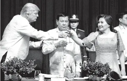  ?? ATHIT PERAWOGMET­HA/REUTERS ?? El republican­o brinda con el presidente filipino, Rodrigo Duterte, y su esposa, Honeylet Avancena.