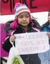  ??  ?? A young member of the Gitxsan First Nation holds up a sign criticizin­g the pipeline.