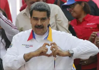  ?? Ariana Cubillos/Associated Press ?? Venezuela’s President Nicolas Maduro gestures a heart symbol to supporters outside the presidenti­al palace last week in Caracas, Venezuela. Mr. Maduro was celebratin­g the anniversar­y of his disputed re-election.