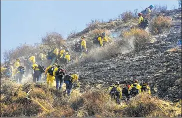  ?? Irfan Khan Los Angeles Times ?? FIREFIGHTE­RS mop up the hillside along the 14 Freeway in the Newhall Pass last month. When the Saddleridg­e fire broke out, Orange County firefighte­rs were dispatched before the request for aid even arrived.