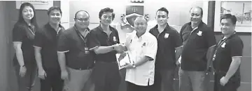  ??  ?? Chan (fourth right) accepts a memento from Siong at the mayor’s office in MBKS.