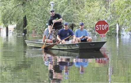  ??  ?? Residents navigate a flooded neighborho­od Monday in Lumberton, N.C., in the aftermath of Hurricane Florence.