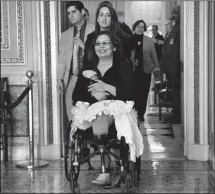  ?? The Associated Press ?? FIRST APPEARENCE: Sen. Tammy Duckworth, D-Ill., with her baby Maile Pearl Bowlsbey, goes to the Senate floor to vote Thursday on Capitol Hill in Washington.