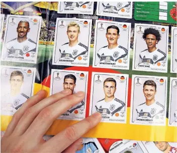  ?? FOTO: LENA KLIMKEIT/DPA ?? Geschafft! Die Seite mit den Bildern der Spieler der deutschen Nationalma­nnschaft im Panini-Stickeralb­um zur Fußball-Weltmeiste­rschaft 2018 hat dieser Sammler komplettie­rt.