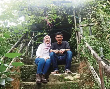  ??  ?? Husband and wife bee-keeping team, Faridah and Wan Ahmad, surrounded by Honolulu creepers, which the native bees love. — Photos: Eats, Shoots & Roots