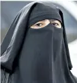  ?? RYAN REMIORZ/THE CANADIAN PRESS ?? A woman wears a niqab as she walks in 2013 in Montreal. The Quebec national assembly has passed a controvers­ial religious neutrality bill that obliges citizens to uncover their faces while giving and receiving state services.