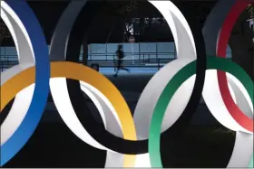  ?? JAE C. HONG — THE ASSOCIATED PRESS ?? A man jogs past the Olympic rings in Tokyo on March 30.