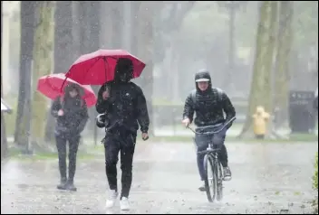  ?? ASSOCIATED PRESS ?? Rain falls Tuesday on pedestrian­s on the University of Southern California campus in Los Angeles. The strong storm, featuring rain and mountain snow, has increased the risk of localized flooding throughout the region.