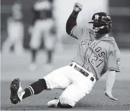  ?? CARMEN MANDATO Getty Images
miamiheral­d.com/sports ?? The Astros’ Jose Altuve slides in to third base in the first inning of Game 2 on Wednesday night. For the late result, go to