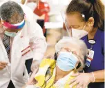  ?? STEPHEN M. KATZ/STAFF ?? CVS pharmacist Kevin Gordon administer­s the COVID0-19 vaccinatio­n to Jeanne
Archer, 94, as Nancy Rose,
RN, comforts her during Saturday’s vaccinatio­n clinic for staff and residents at Beth Sholom Village.