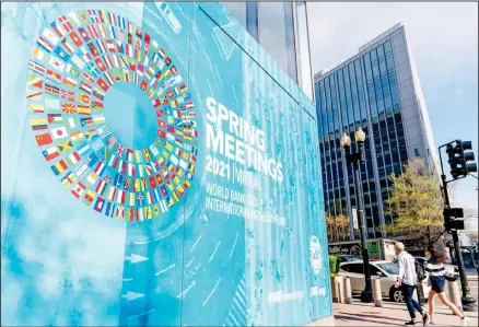  ??  ?? A poster is displayed on the Internatio­nal Monetary Fund building, April 5, 2021, in Washington. The IMF and the World Bank open their virtual spring meeting. (AP)