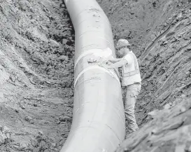  ?? Richard Tsong-Taatarii / Star Tribune file ?? A pipe fitter puts the finishing touches on the replacemen­t of Enbridge Energy's Line 3 crude oil pipeline in Superior, Minn.