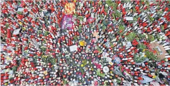  ?? FOTO: HARALD TITTEL/DPA ?? Blumen und Kerzen vor der Porta Nigra erinnern an die Opfer der Amokfahrt vom 1. Dezember 2020.