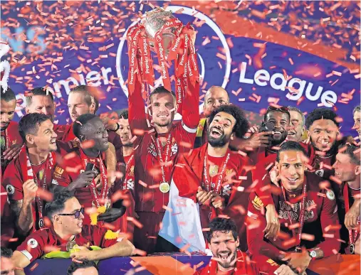  ??  ?? CHAMPIONS: Reds captain Jordan Henderson, centre, and team-mates celebratin­g with the Premier League trophy back in July