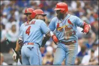  ?? The Associated Press ?? CARRYING THE CARDS: St. Louis Cardinals’ Marcell Ozuna, right, celebrates with teammates Yadier Molina, left, and Paul Goldschmid­t, center, after hitting a two-run home run during the seventh inning of Saturday’s game against the Chicago Cubs in Chicago.