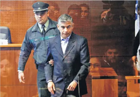  ??  ?? ► El general (R) Gonzalo Blu ingresa a la audiencia de control de detención celebrada ayer en Santiago.