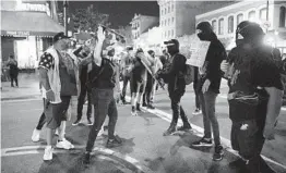  ?? KRISTIAN CARREON ?? Demonstrat­ors protesting the outcome of the Breonna Taylor investigat­ion get into a heated argument with pedestrian­s walking by in downtown San Diego.