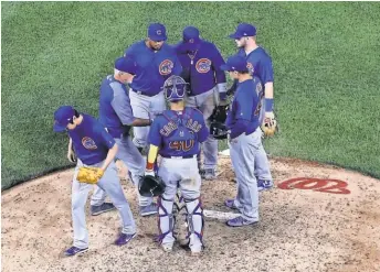  ?? ROB CARR, GETTY IMAGES ?? Cubs players and manager JoeMaddon gather to bid farewell to reliever Koji Uehara, one of eight pitchers Chicago used in a 3- hour, 54- minute win at the Nationals onMonday.