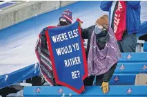  ?? [AP PHOTO/BRETT CARLSEN] ?? Bills fans hold a pennant reading “Where else would you rather be?” before an NFL wild-card playoff game against the Colts on Jan. 9 in Orchard Park, N.Y.