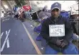  ?? JANE TYSKA — STAFF PHOTOGRAPH­ER ?? Shawn Moses waits with his belongings as Oakland city employees clean a homeless camp on Northgate Avenue.