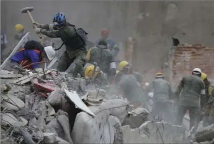 ?? NATACHA PISARENKO, THE ASSOCIATED PRESS ?? Rescue workers search for survivors at an apartment building that collapsed during the . Tuesday’s earthquake killed more than 200 people.